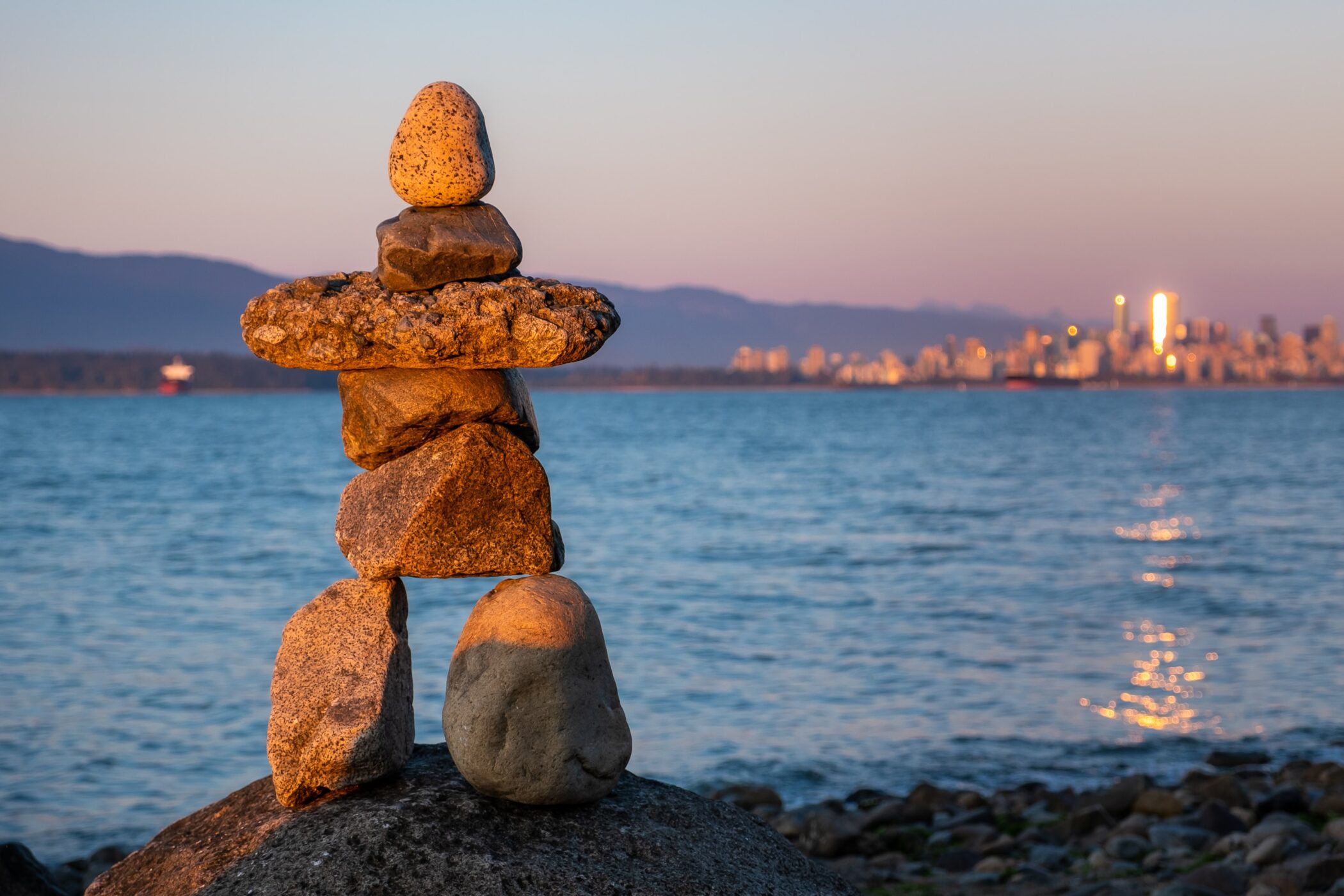 An inukshuk with a water background in Vancouver.